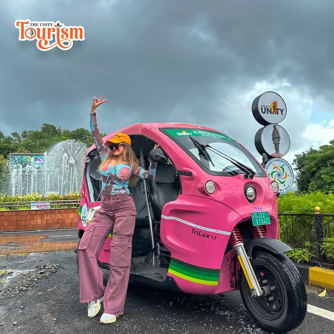 Tourist posing with pink electric rickshaw near Statue of Unity entry point