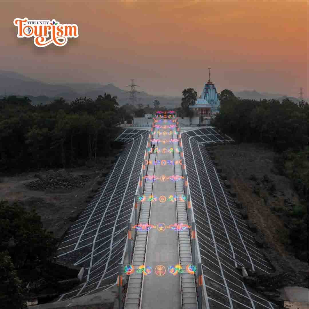 A sunset view of a bridge adorned with colorful lights, creating a striking silhouette.