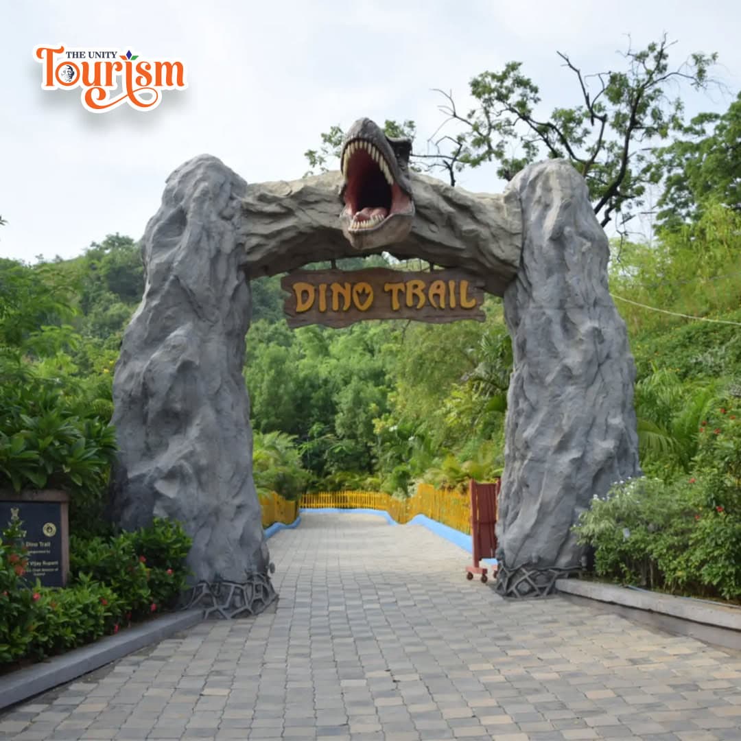 A stone archway marks the entrance to the dinosaur trail, blending seamlessly with the surrounding landscape.