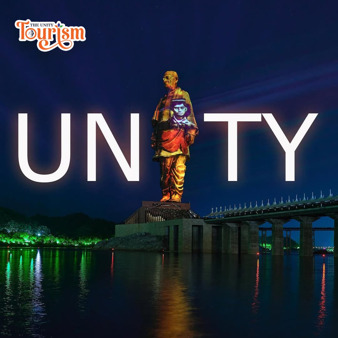 Statue of Unity illuminated with vibrant laser beams during evening projection show.