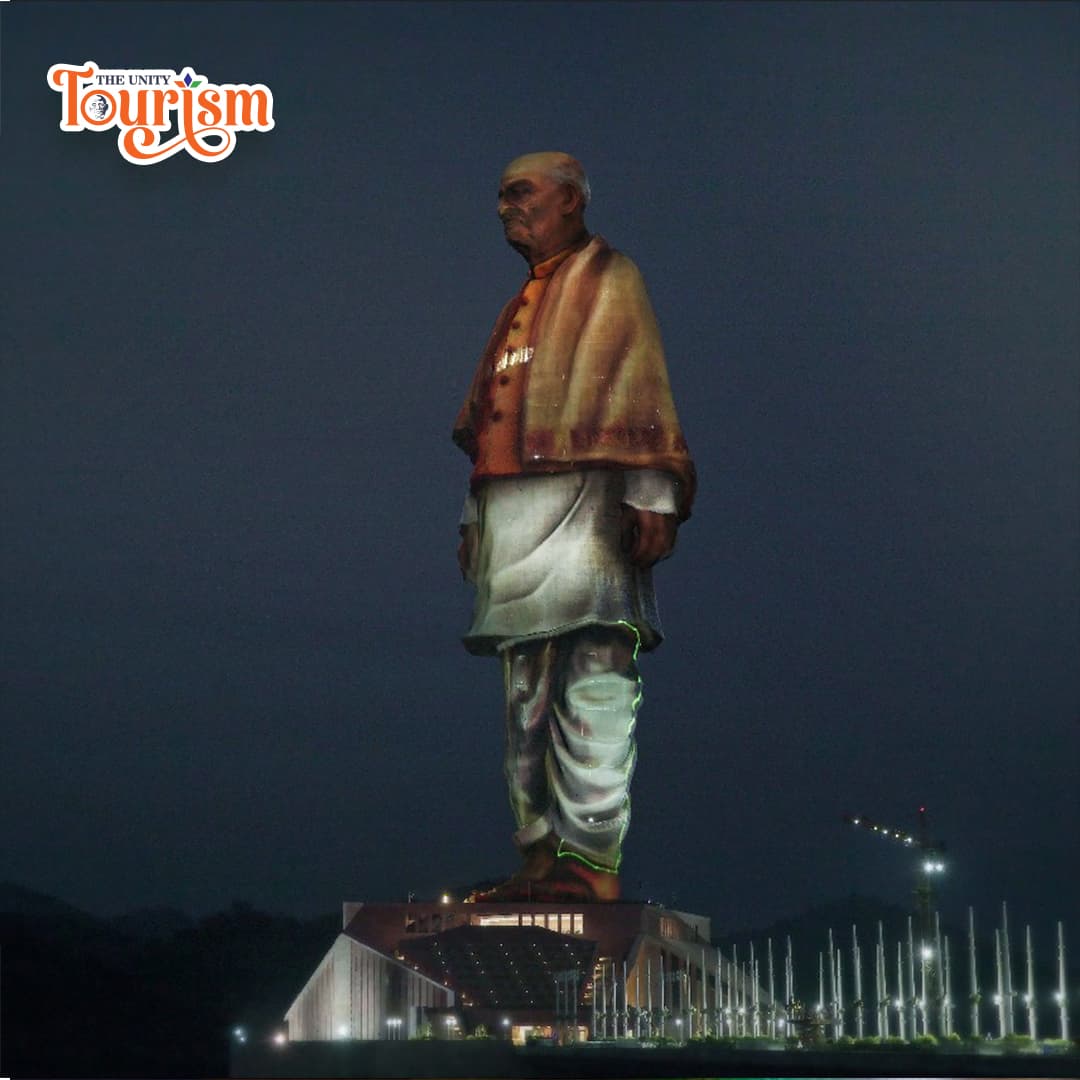 Night view of Statue of Unity with artistic laser mapping display.