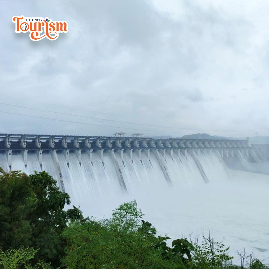 Wide-angle shot of Sardar Sarovar Dam surrounded by green hills