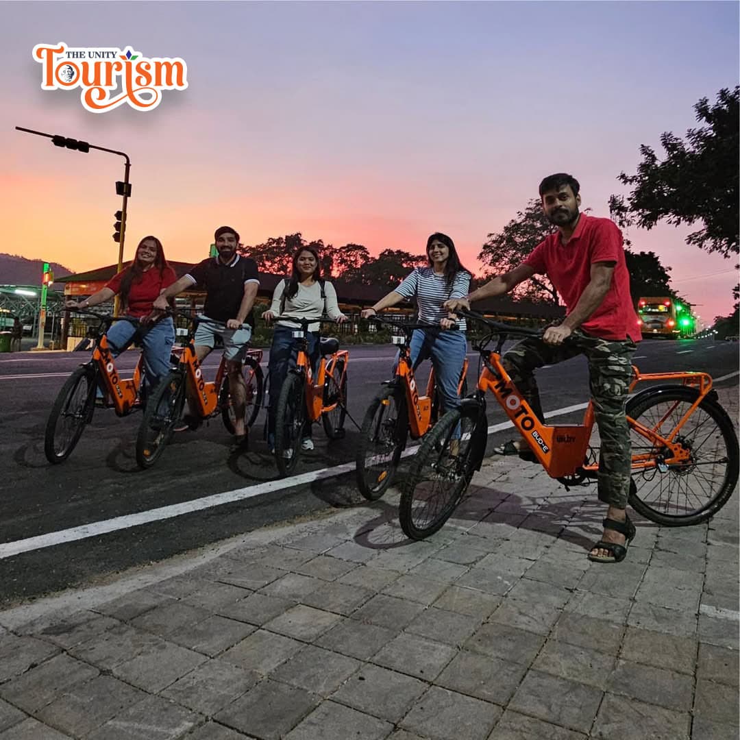 Couple exploring Statue of Unity Riverfront on bicycles with scenic surroundings