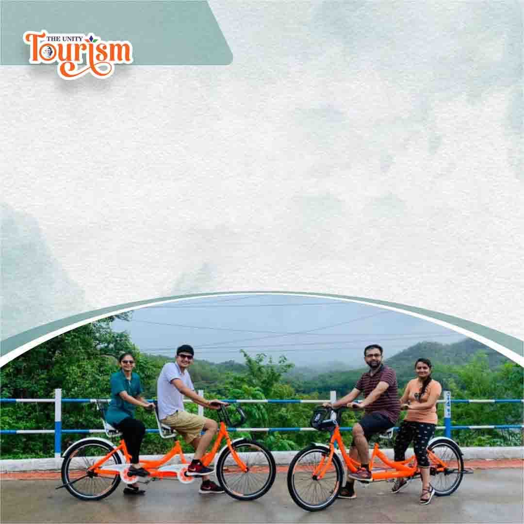 Tourists enjoying tandem cycling along the Statue of Unity riverfront pathway.