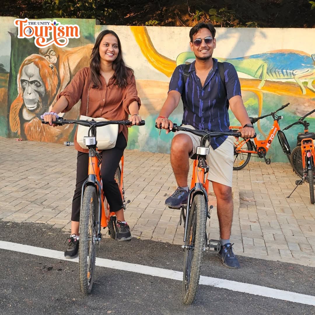 Tourists riding bicycles together near Statue of Unity riverfront path