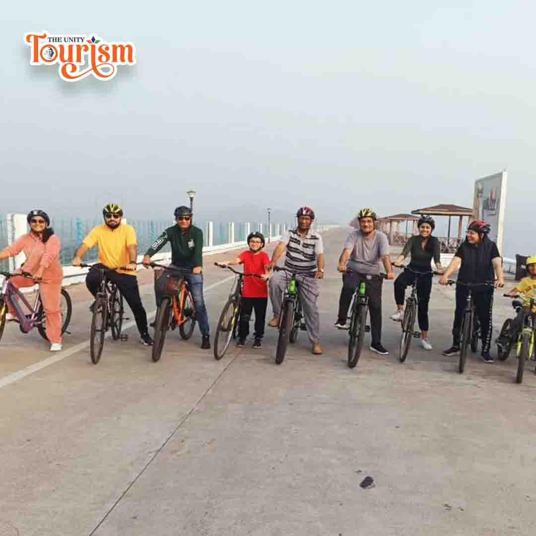 Leisure cycling couple exploring Statue of Unity riverfront attraction